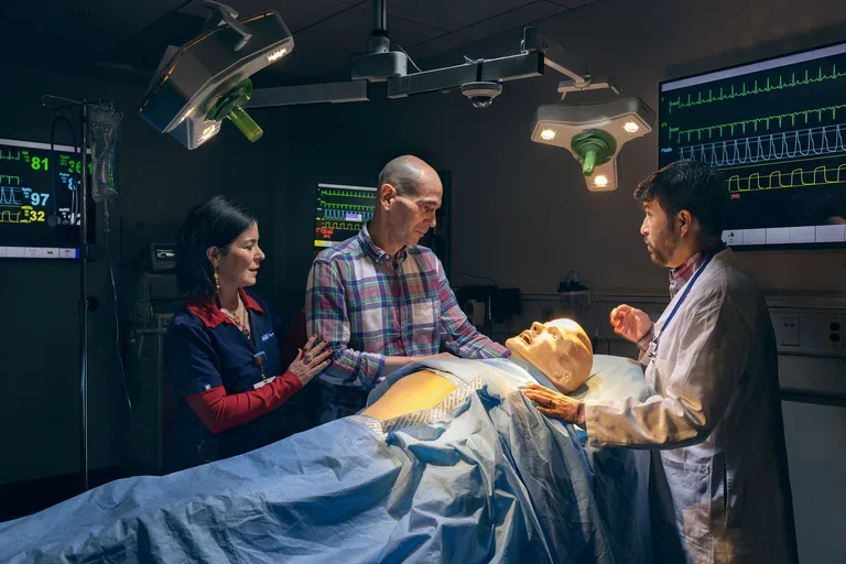 Yvonne Caro Caro performs a simulation with a mannequin and two other actors 